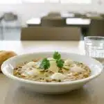 Cérésoto végétarien crémeux dressé au cercle, mozzarella et parmesan, servi en assiette sur un plateau de self de restauration collective.