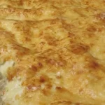 Plaque de lasagnes gratinées sortie du four, tenue devant le passe