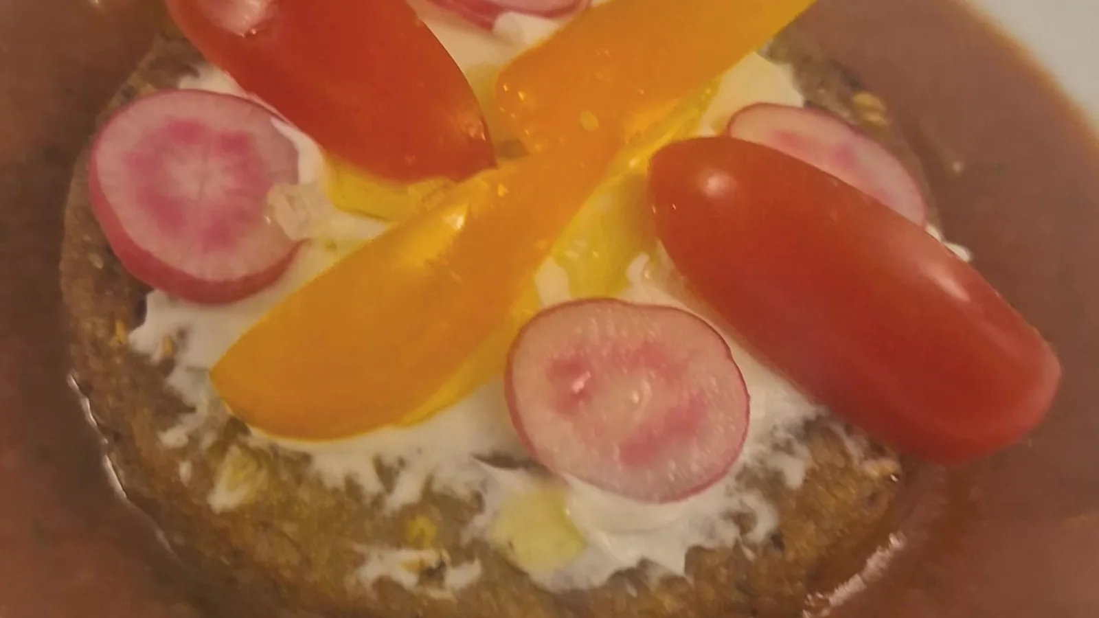 Palet végétal en entrée tiède, fromage blanc, radis, tomates cerises et basilic sur un coulis de tomate