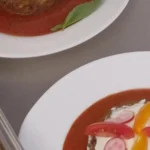 Assiettes de palets végétaux dorés dressées sur un coulis de tomate, prêtes au passe