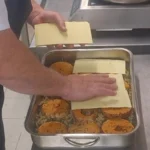 Montage d'un plat de lasagnes en bac, plaques posées sur l'appareil au seitan