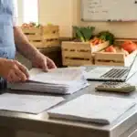 Chef de collectivité triant ses factures d'achats avant la télédéclaration ma cantine